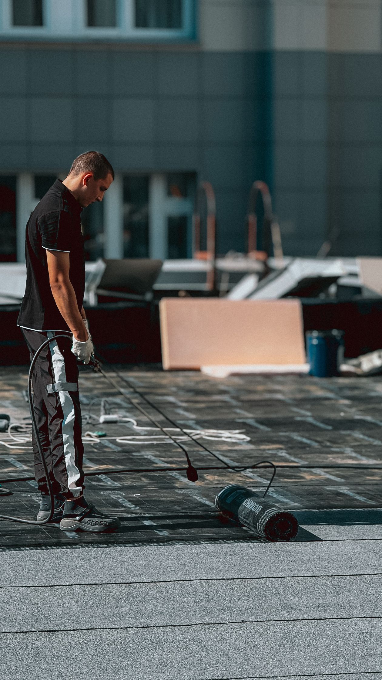Worker rolling a waterproof coating onto a flat roof
