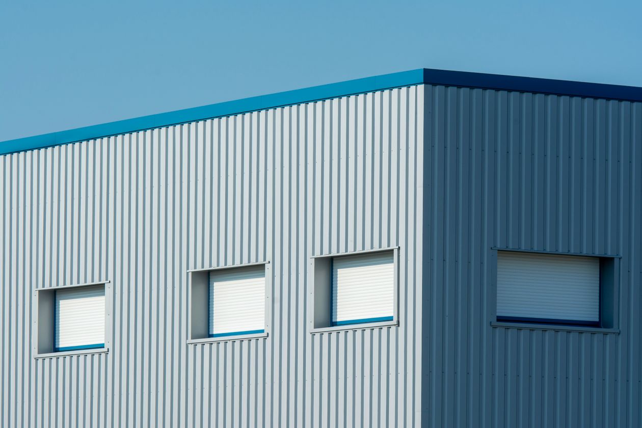 Industrial building clad in concealed-fastener metal wall panels