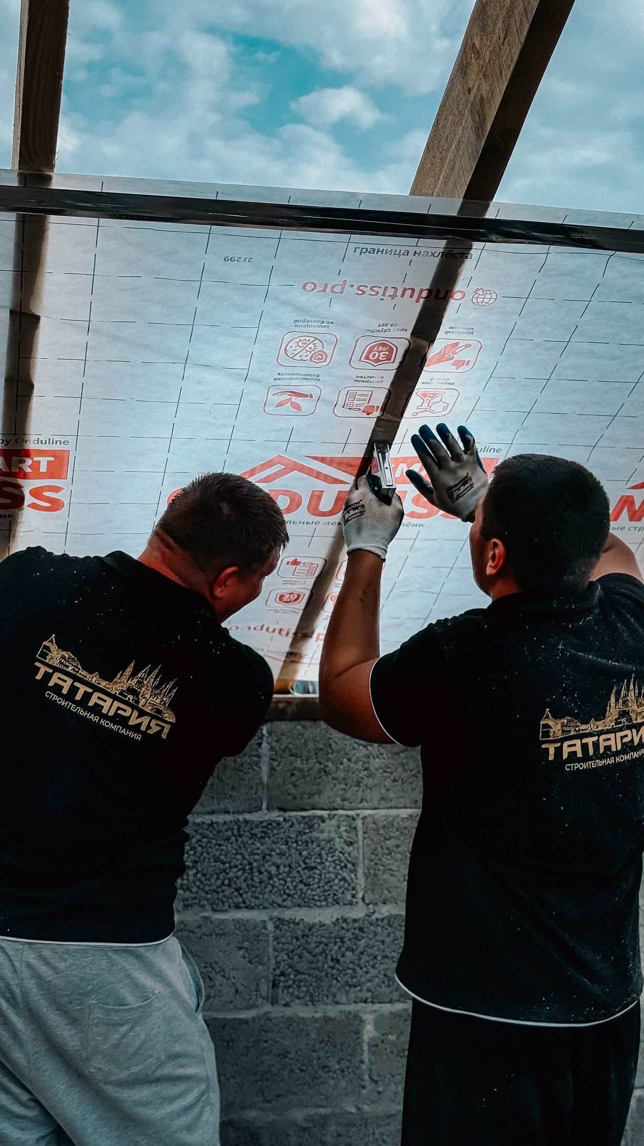 Roofers installing insulation boards on a flat roof